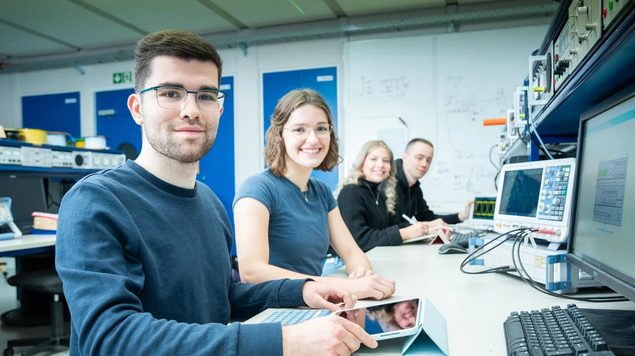 Studierende im Labor mit Computern und Geräten