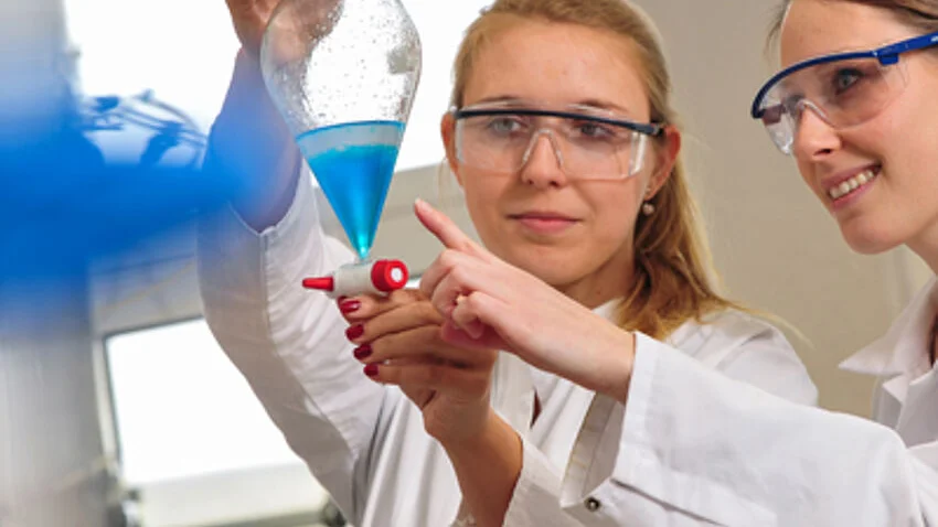 Zwei Studentinnen in Laborkitteln im Labor