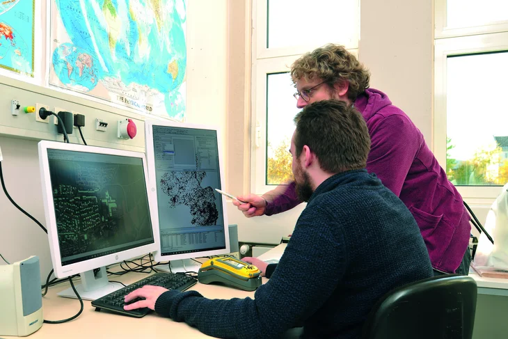 TH Bingen Mitarbeiter und Student sehen sich Ergebnisse der Wetterstation am PC an.