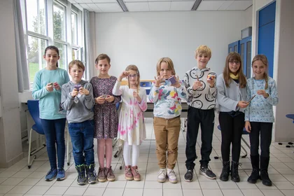 Das Bild zeigt Teilnehmende der Kinderhochschule mit ihren fertiggestellten Gegenständen.