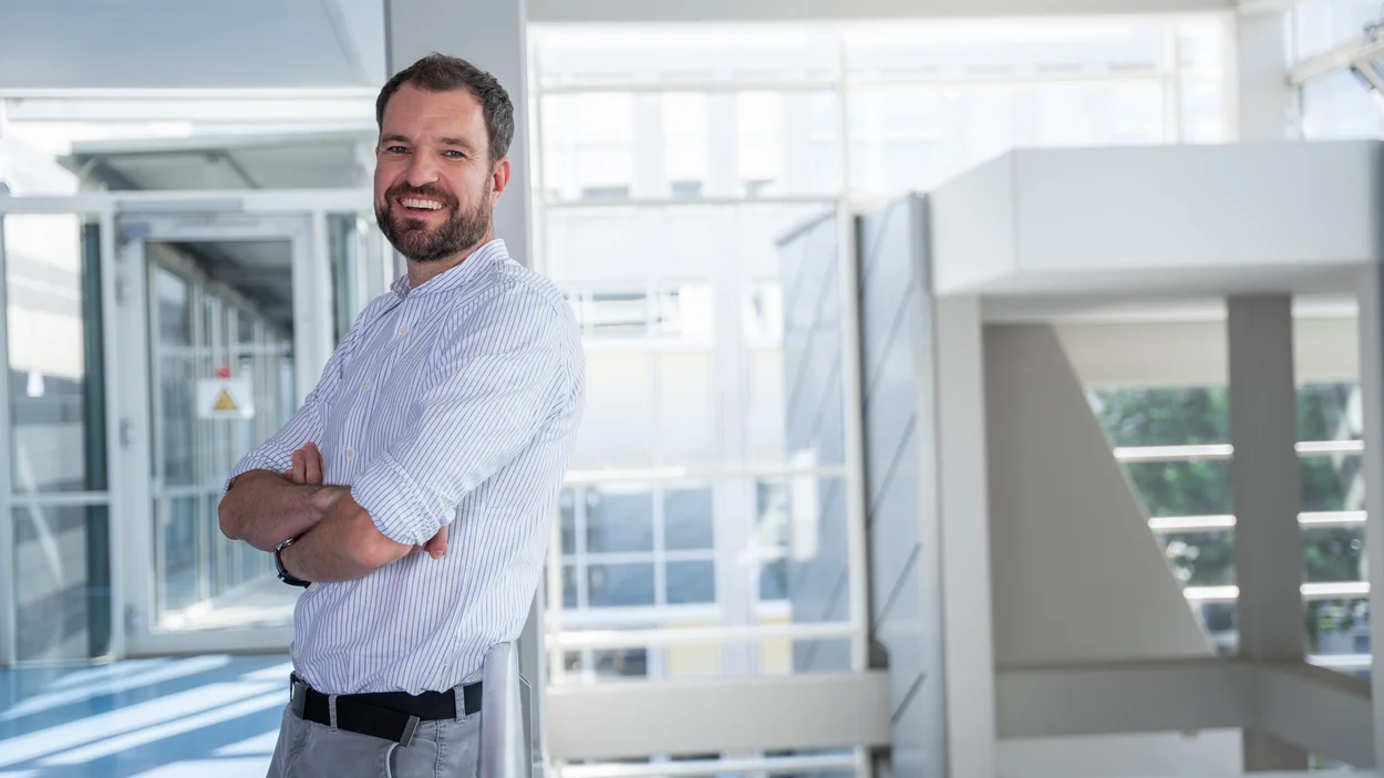 Das Bild zeigt Prof. Dr. Andre Deppermann im Treppenhaus des TH-Gebäudes 5.