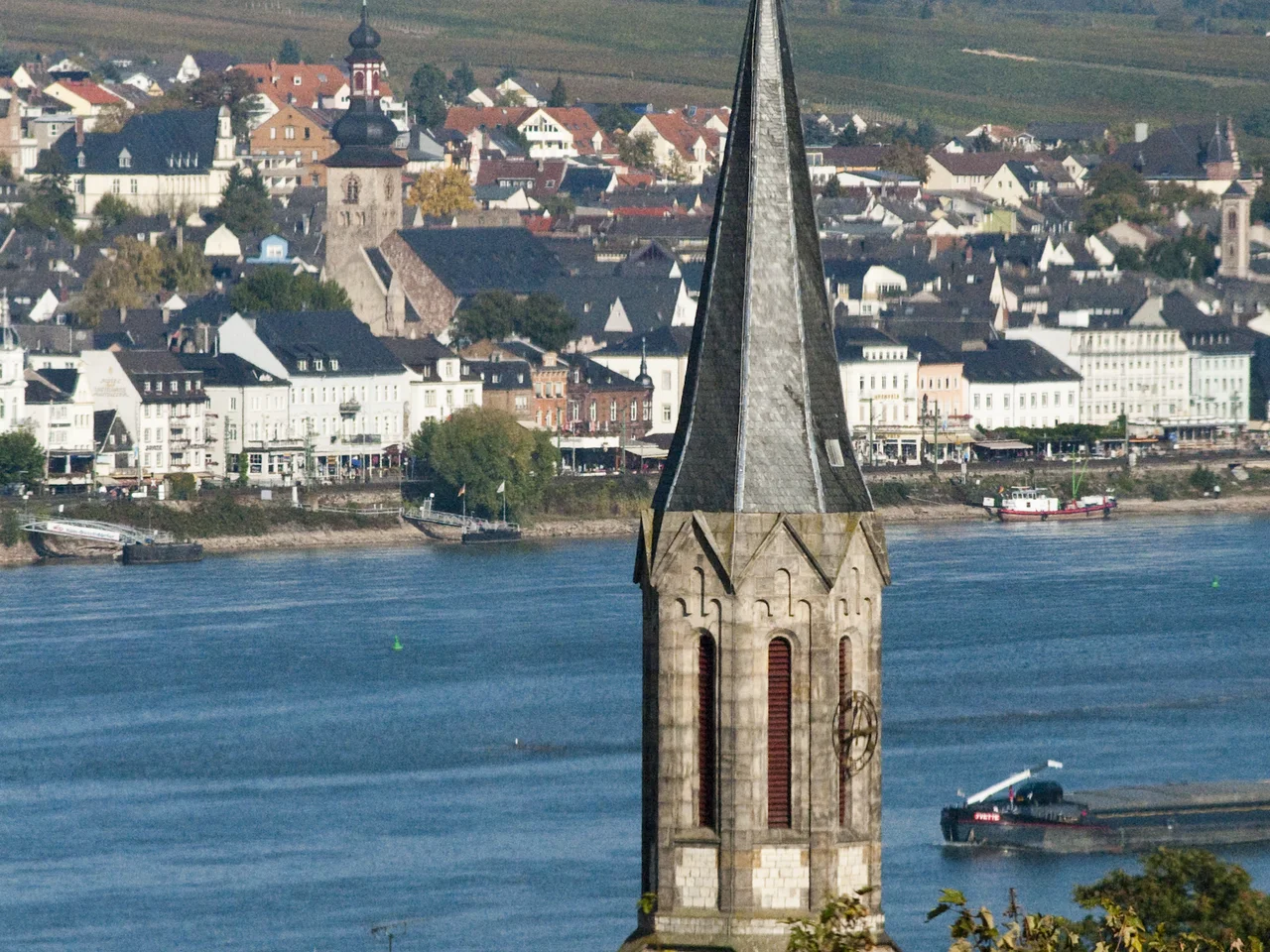 Blick auf einen Kirchturm und den Rhein in Bingen.