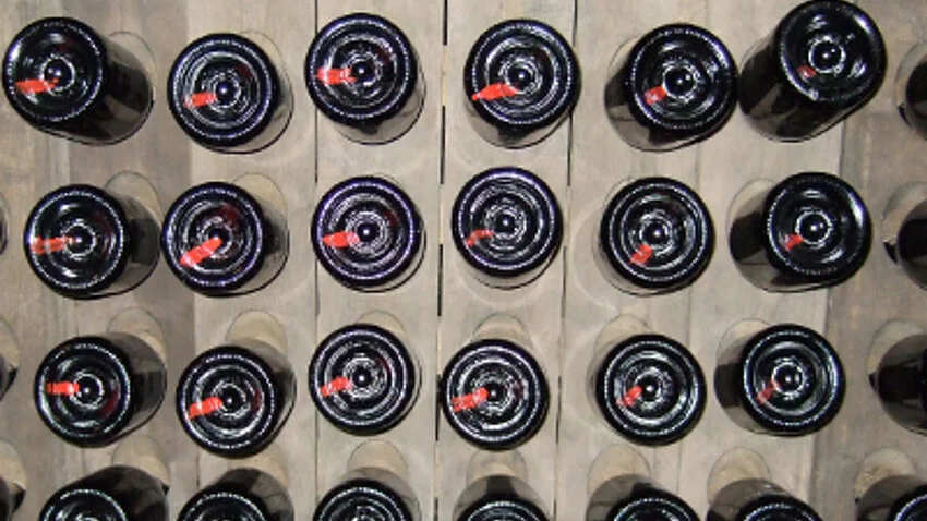 In Draufsicht und im Quadrat angeordnet abgebildete Weinflaschen.