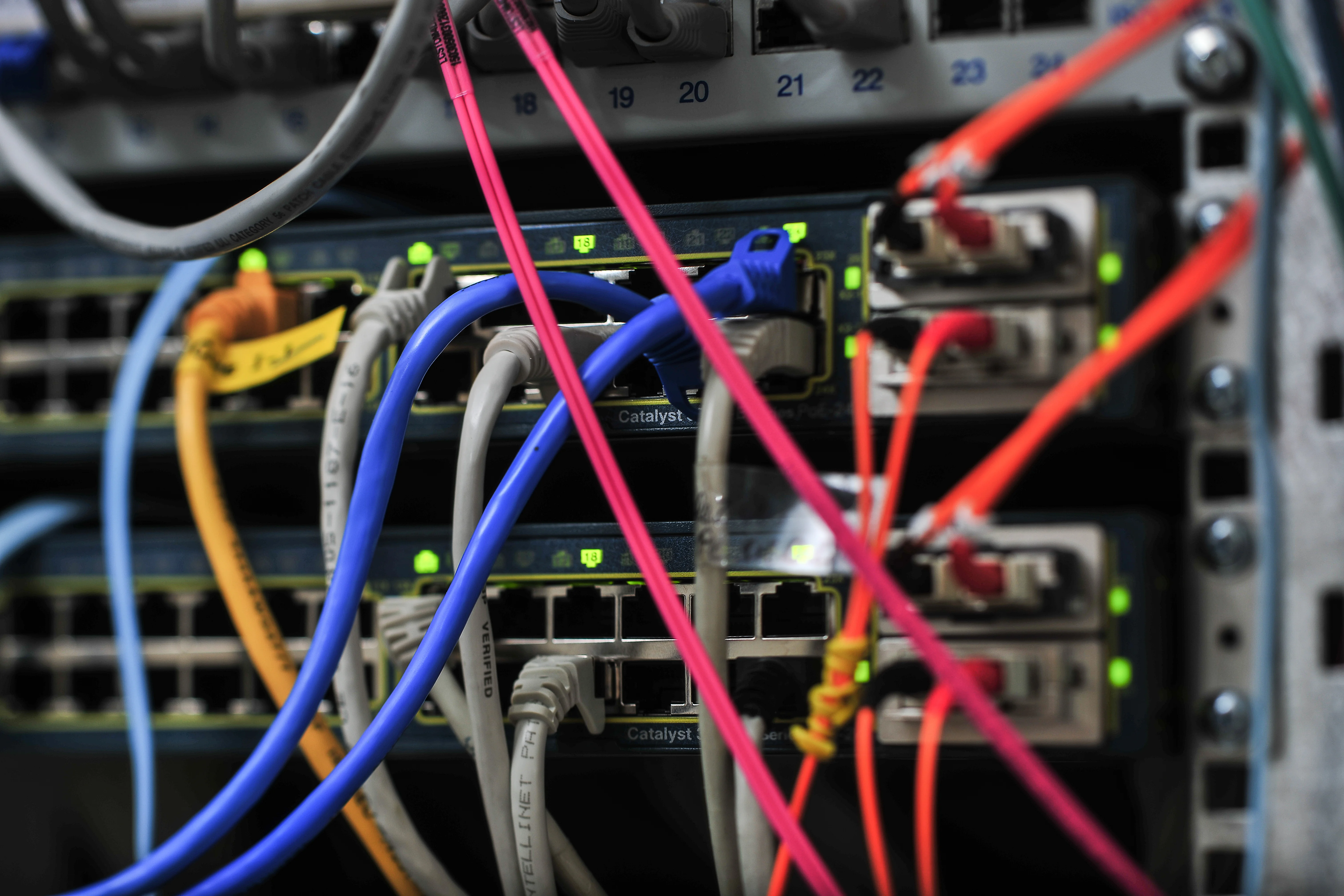 Rückseite eines Rechners mit mehreren angeschlossenen, verschiedenfarbigen Kabeln.